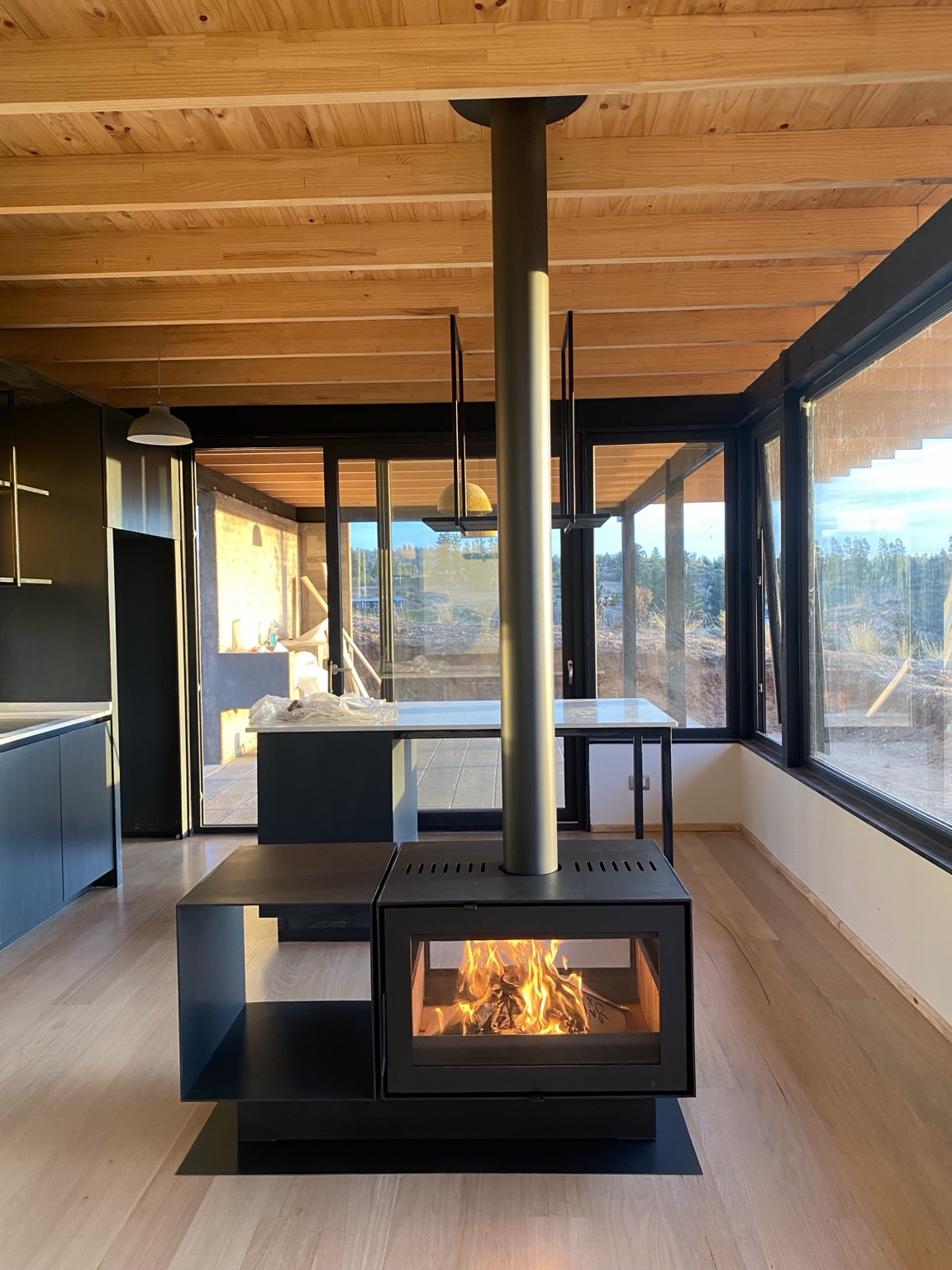 Chimenea de doble vista con leñero lateral fabricada e instalada por Clima Fuego Store